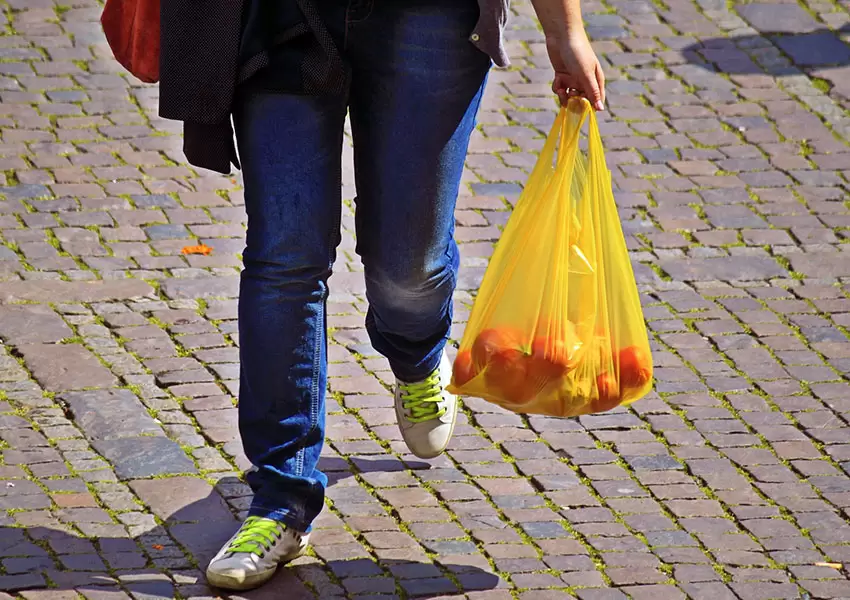 Persona caminando con bolsas de plástico