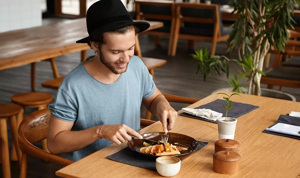 Cliente disfrutando de una cena solo en mesas para uno: nueva tendencia en hostelería